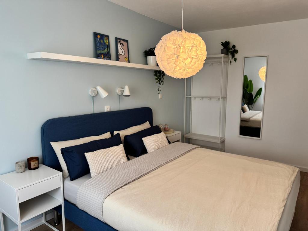 a bedroom with a blue bed with pillows at JUPAS - Premium Apartments in Konz