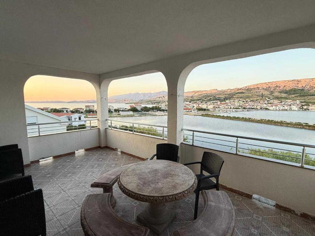 a balcony with a table and chairs and a view of the water at Apartments Anđelka in Pag