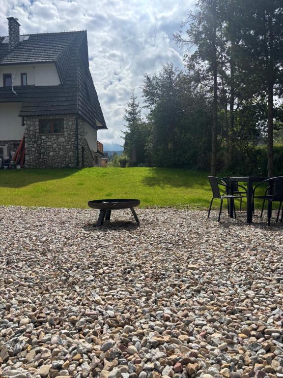 a picnic table and two benches on a rocky ground at Apartamenty u Załogi in Zakopane