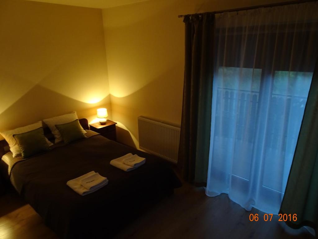 a bedroom with a bed and a window with towels on it at Willa ZŁOTY OGRÓD in Wieliczka