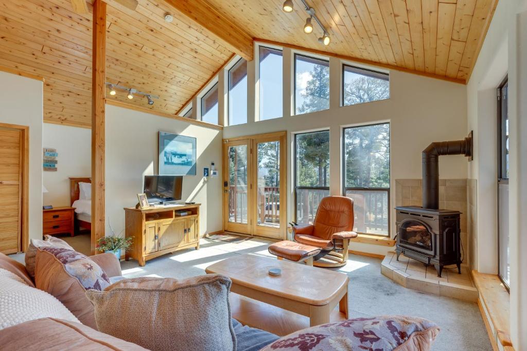 a living room with a couch and a stove at Mtn-View Deck: Cabin Getaway in Angel Fire in Angel Fire
