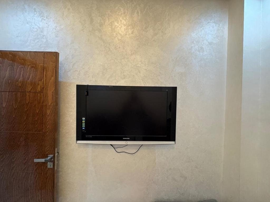 a flat screen tv hanging on a wall at 3 bedroom apartment with living room and terrace 90metre in El Harhoura