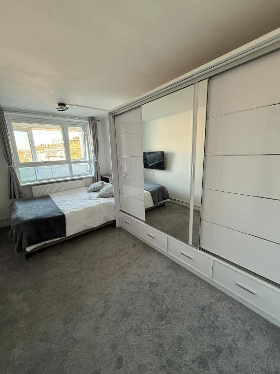 a bedroom with a bed and a large mirror at Private Room with King Size Bed, TV and Shared Bathroom in London