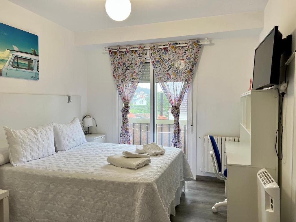 a bedroom with a large bed with a window at El Marquesado de Santiago en Milladoiro in Amés