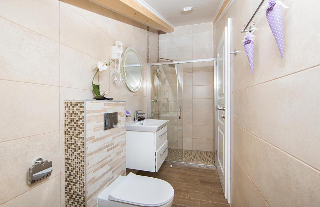 a small bathroom with a toilet and a sink at Boutique Hotel Melissa in Poreč