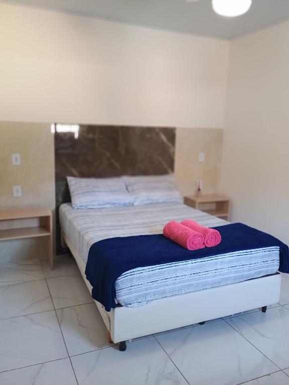 a bed with two pink pillows on top of it at Espaço familiar 3 in Vila Velha