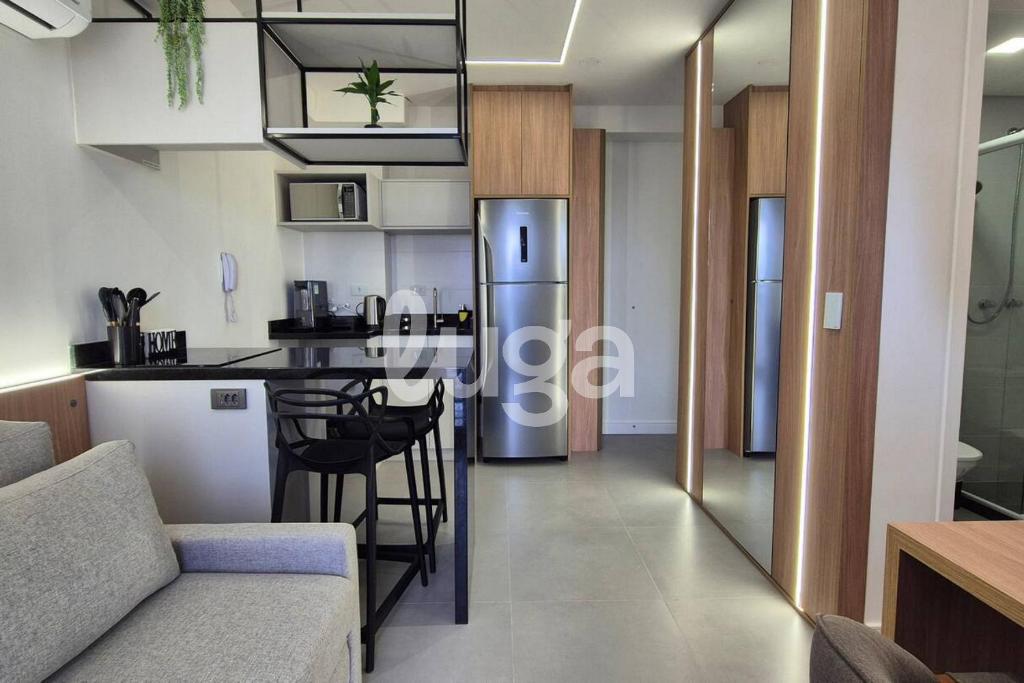 a kitchen and living room with a refrigerator and a table at Studio Resort Piscina Aquecida GYM Bem localizado in Curitiba