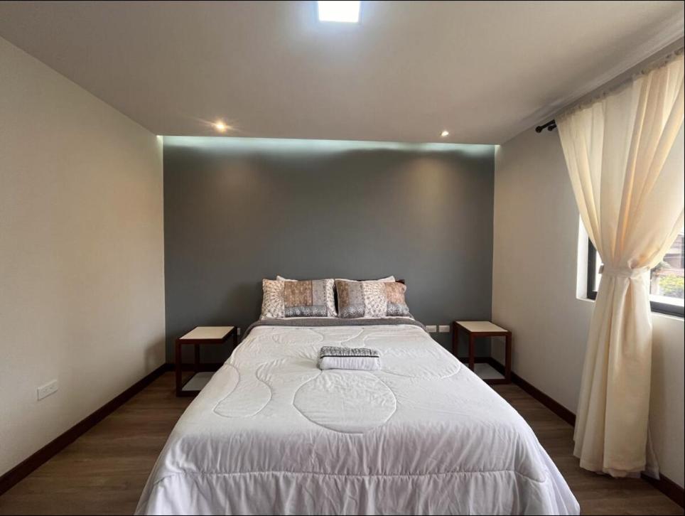 a bedroom with a large bed and a window at Casa Equipada cerca Hotel Oro Verde Cuenca in Cuenca