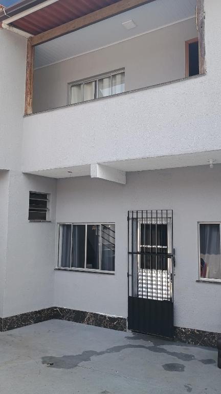 a white building with a gate in front of it at Espaço familiar 2 in Vila Velha