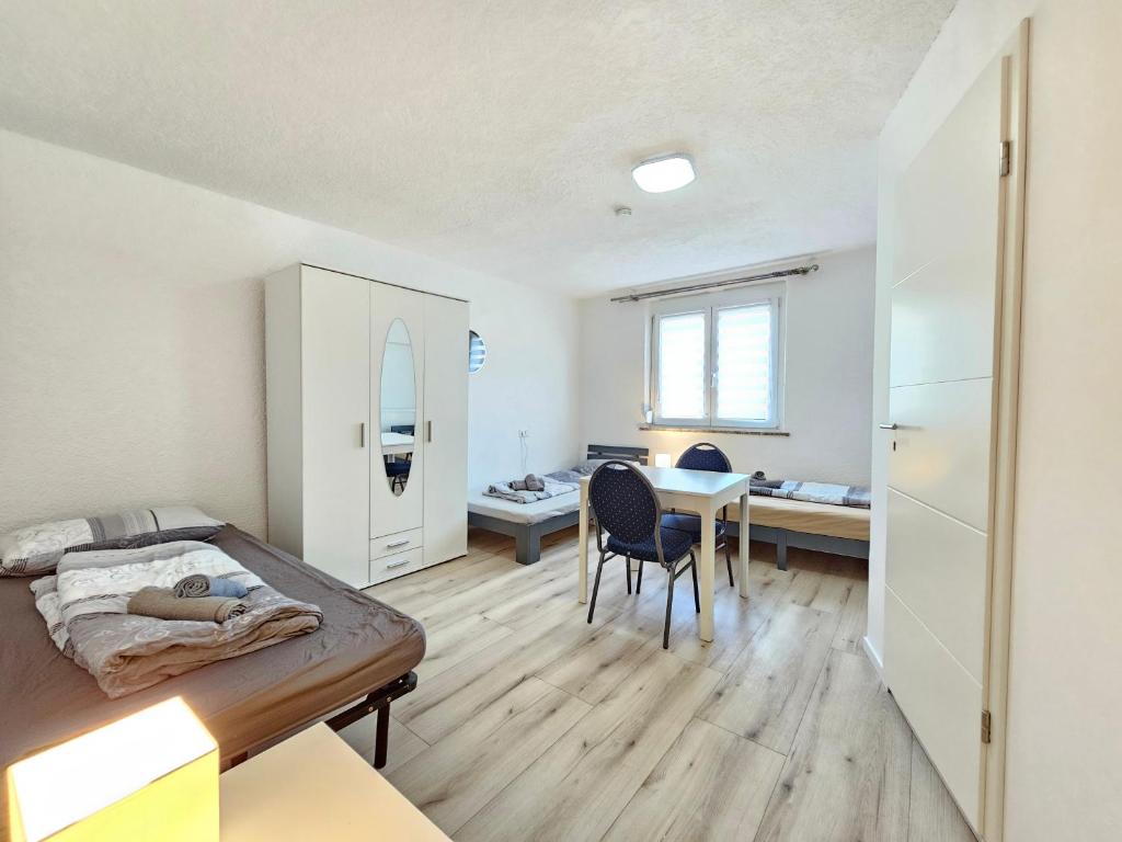 a bedroom with a bed and a desk and a table at Wohnreich Ulm 1 room apartment 4th floor Room 3 in Ulm