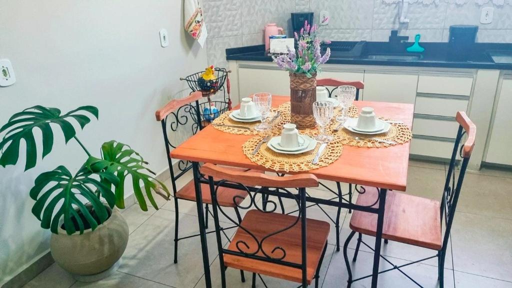 a table with chairs and a table with cups and saucers at Ao lado da Igreja Matriz, Hospedagem de Charme in Santa Rita do Sapucaí