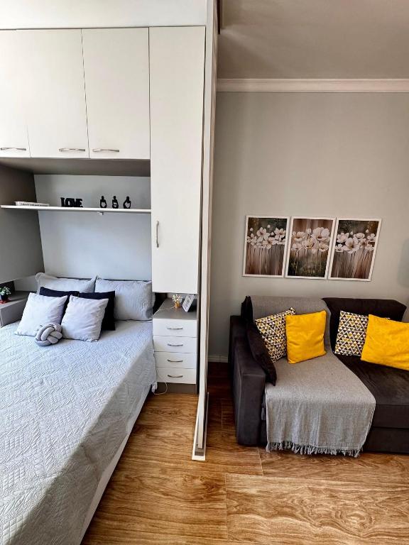 a living room with a bed and a couch at Estúdio aconchegante no centro com elevador in Nova Friburgo