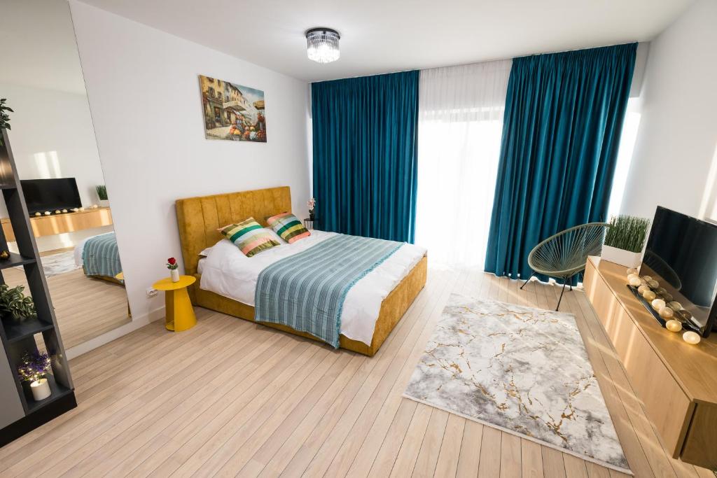 Cette chambre comprend un lit avec des rideaux bleus et une télévision. dans l'établissement High comfort by Best Residence, à Bucarest