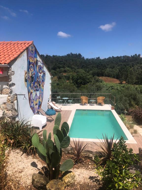 a swimming pool in front of a house at Lameira Da Longra - Wellness Retreat in Tomar
