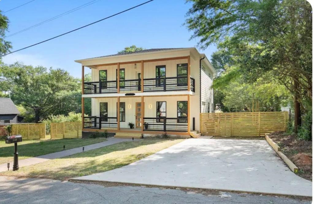 a large yellow house with a large driveway at Mystic Falls Downtown Modern Farmhouse in Covington