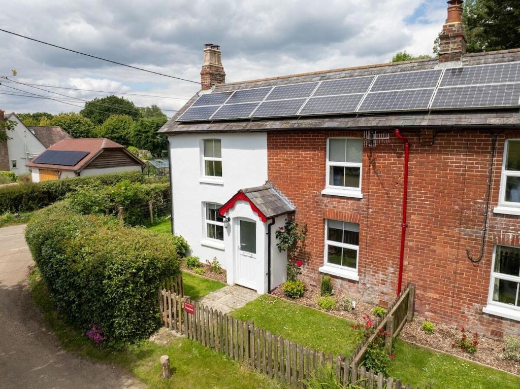 a house with solar panels on the roof at Rose cottage in Bransgore