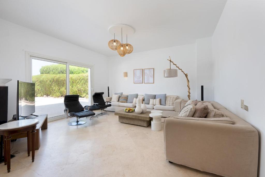 a living room with white furniture and a large window at VESTA - El Gouna Residence in Hurghada