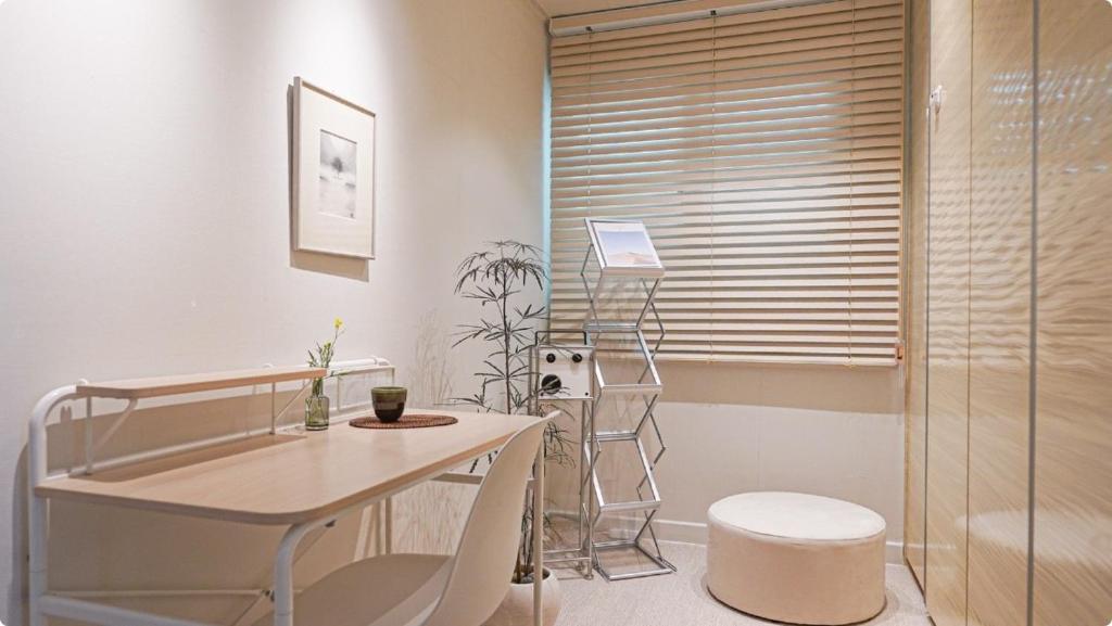 a bathroom with a glass shower and a desk and chair at Villa de EL 1 in Busan