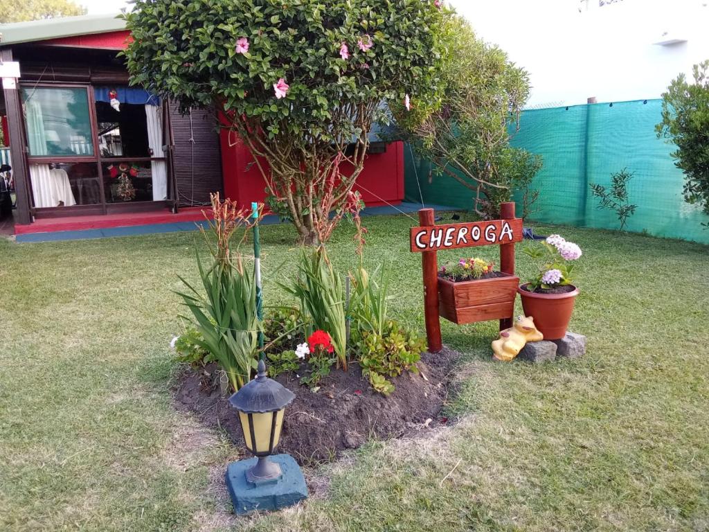 a garden with a sign and flowers and a street light at Cheroga in La Pedrera