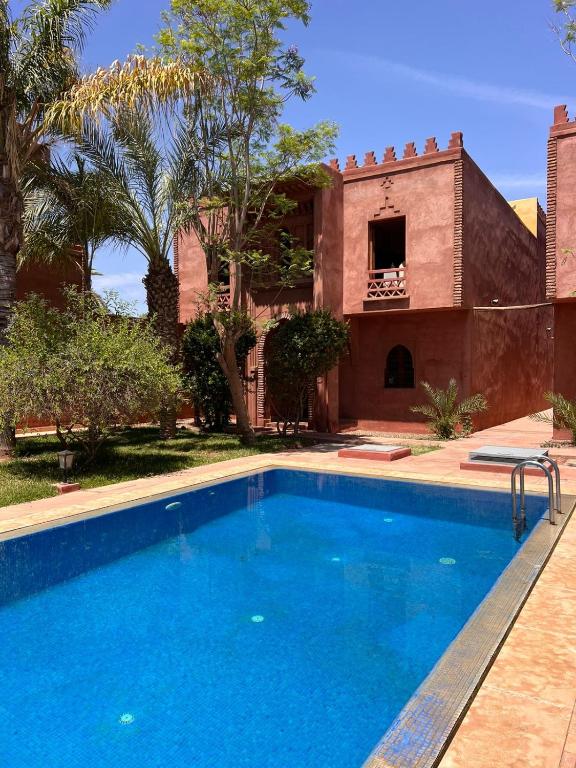 a swimming pool in front of a house at Riad du Bab atlas in Marrakesh