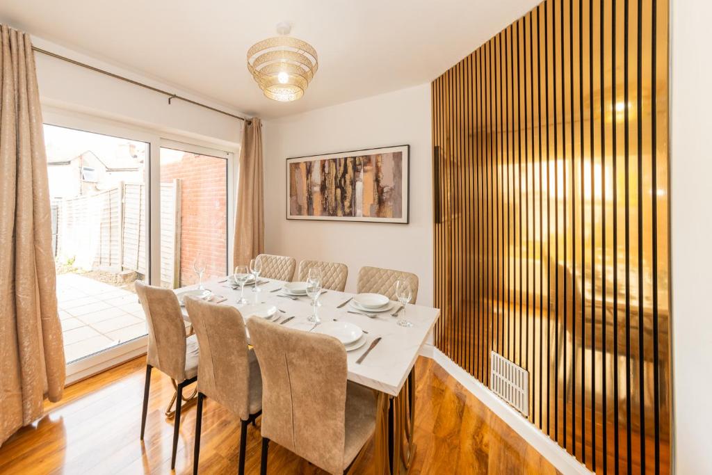 una sala da pranzo con un tavolo e una grande finestra di Free Parking 4-Bed Fully Equipped Home a Earley