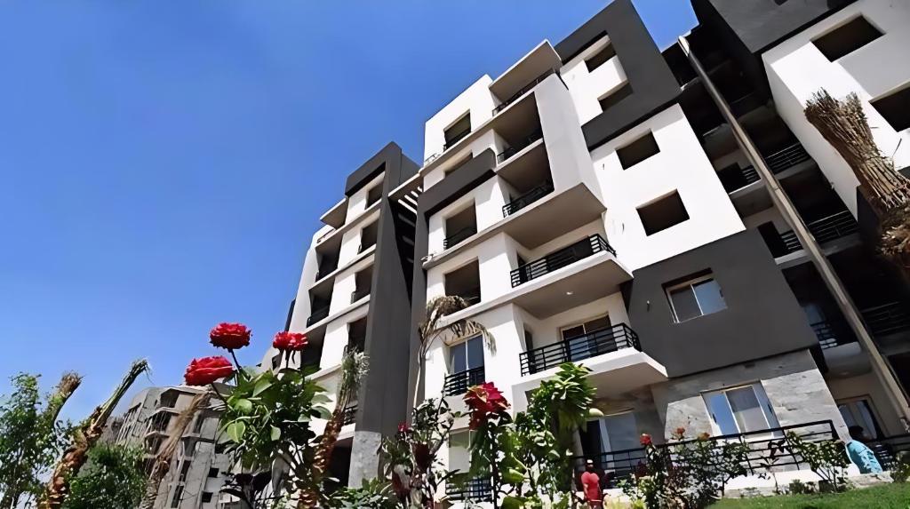 Sheikh ZayedにあるModern Flat at Shiekh Zayedの赤い花の建物