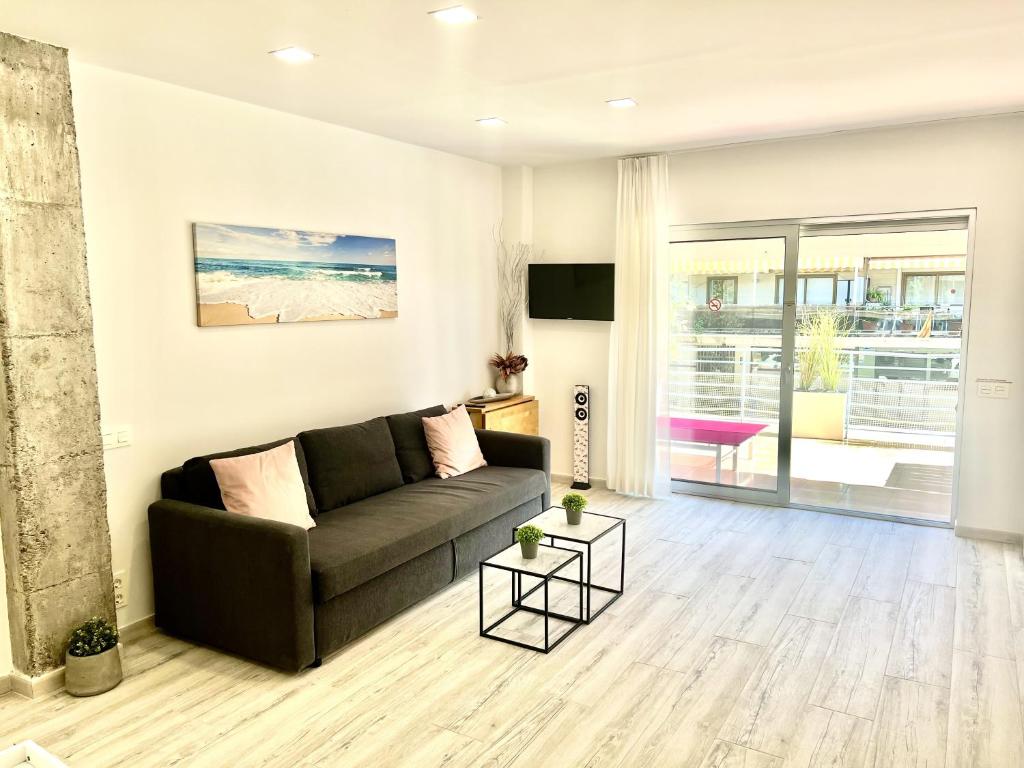 a living room with a couch and a view of the ocean at Apartamento con piscina y terraza recién reformado in Platja  d'Aro