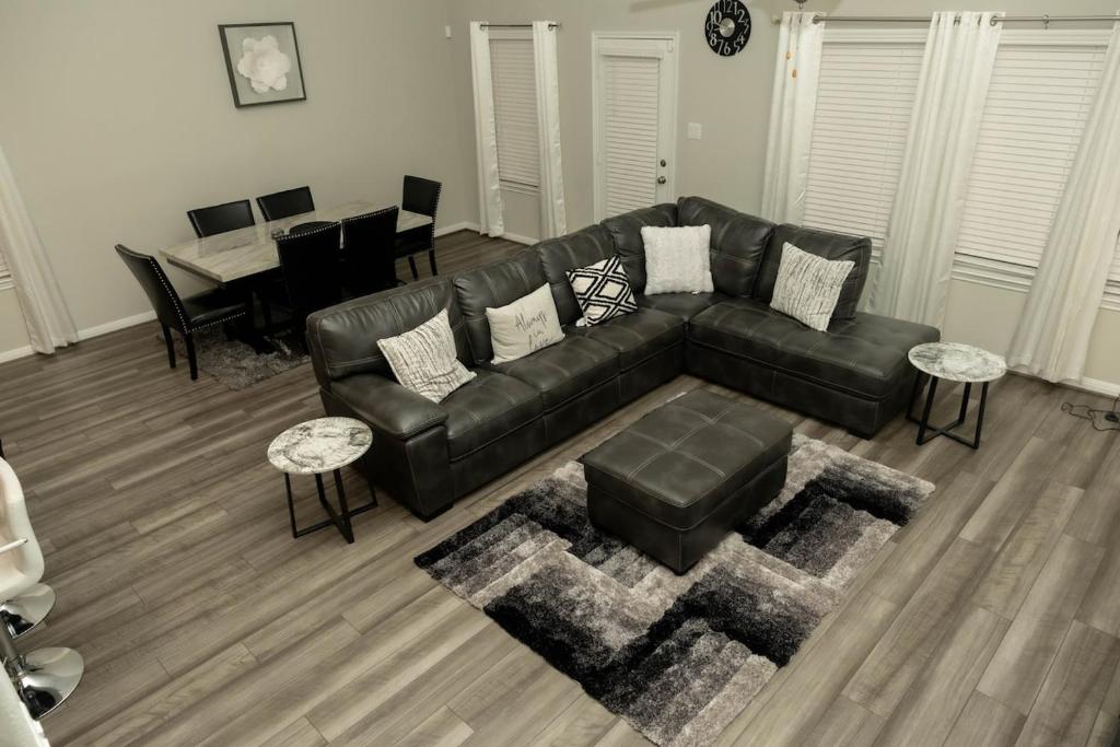 a living room with a black leather couch and a table at Private Room in Richmond, TX in Richmond