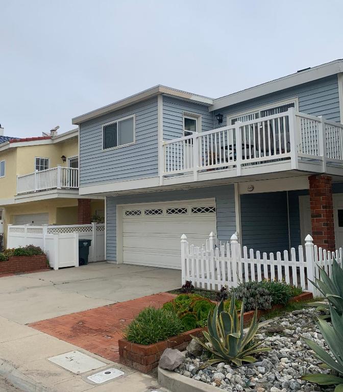 a large house with a white fence in front of it at Ocean Blue in Oxnard