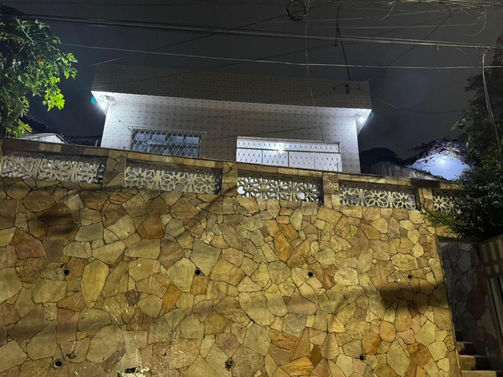 a stone wall in front of a building at night at Bela casa em Olinda in Olinda