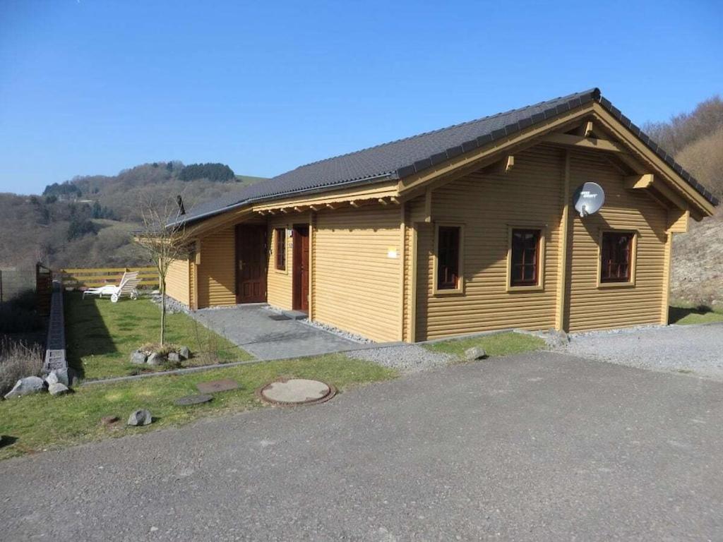 un petit bâtiment en bois avec une route devant lui dans l'établissement Holiday home with 2 bedrooms, à Rieden