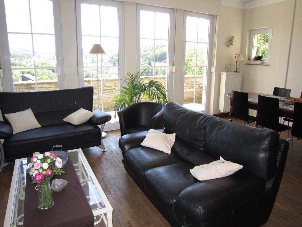 una sala de estar con 2 sofás de cuero negro y una mesa. en Charming house with view of the Bouillon Castle, en Bouillon