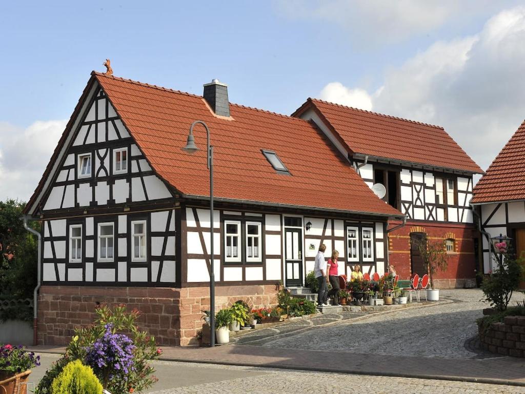 a black and white building with red roof at Holiday home Bauernhauschen in the Rhon in Bernshausen