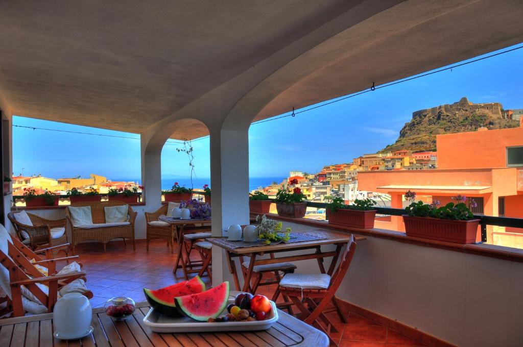 einen Balkon eines Hotels mit einem Tisch mit Wassermelone in der Unterkunft B&B L'Umbra di lu Soli in Castelsardo