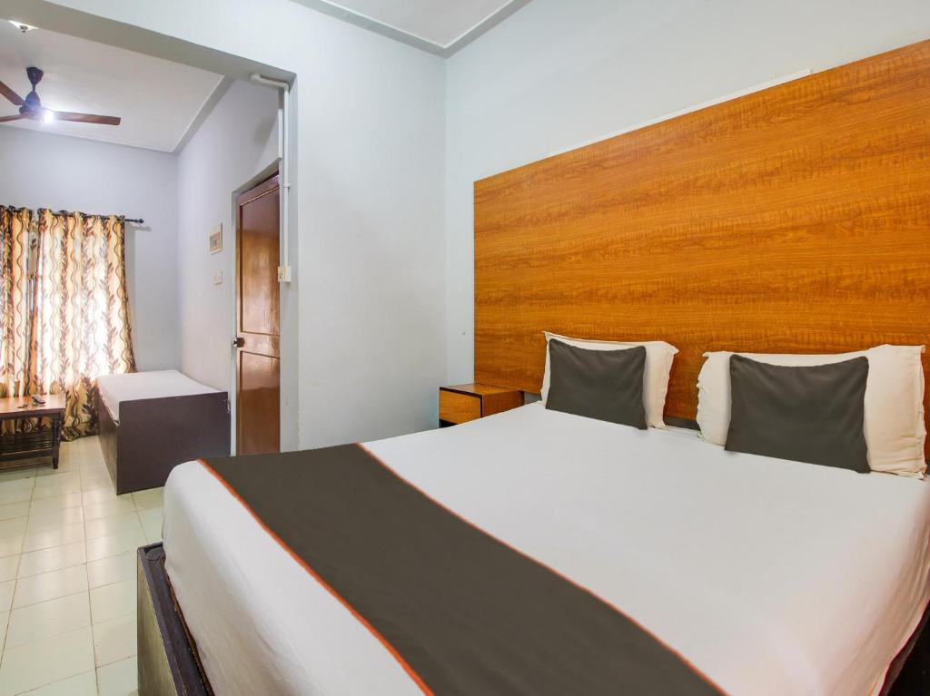 GoaCollection O Maizons Lakeview Resort的卧室里有一张带木质床头板的大床