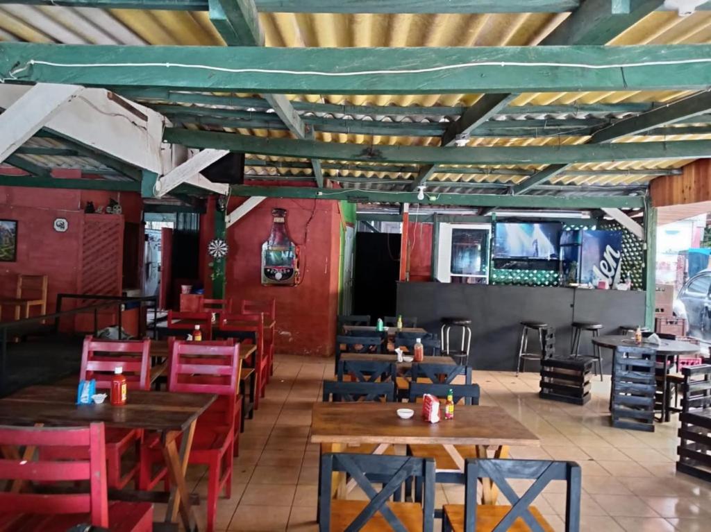 MexicanosにあるHades Metal Barのダイニングルーム(木製テーブル、赤い椅子付)