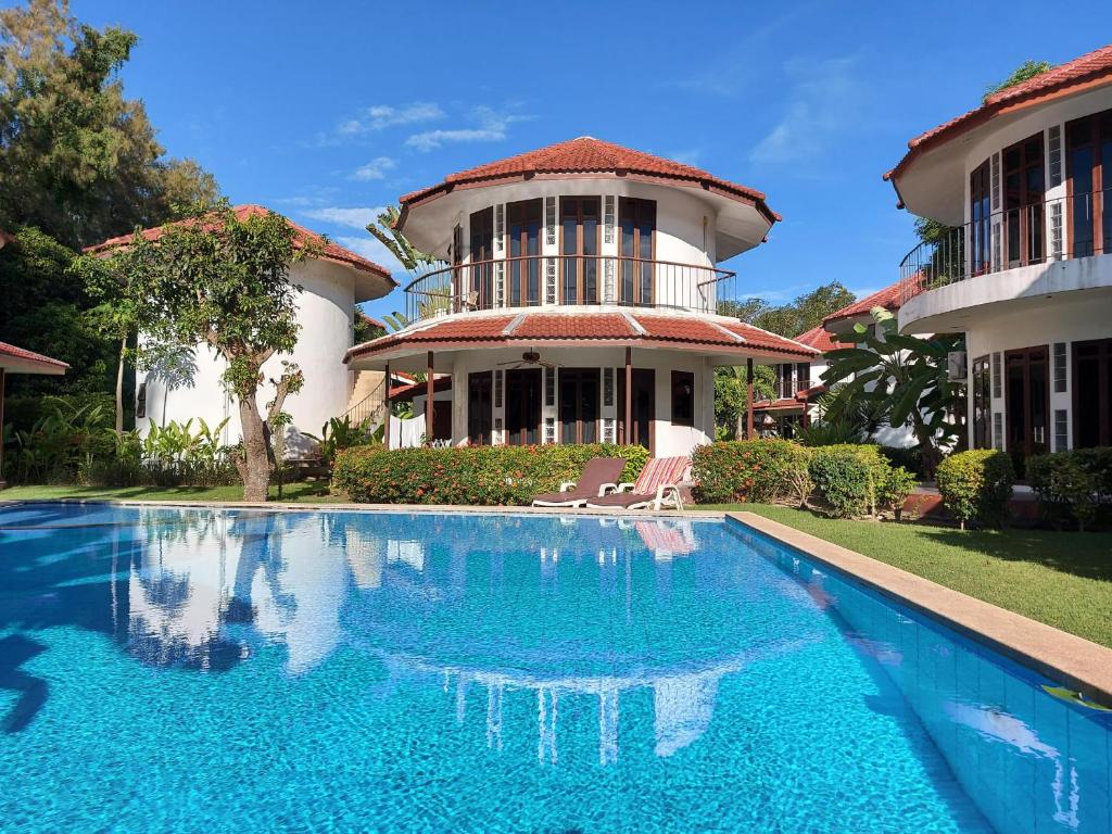 a house with a swimming pool in front of a house at Mango Paradise, in der Nähe des Black Mountain Golf Clubs in Hua Hin