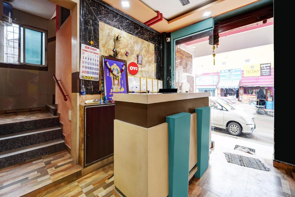 a lobby of a restaurant with a counter and stairs at Hotel O Pothini Palace in Palani