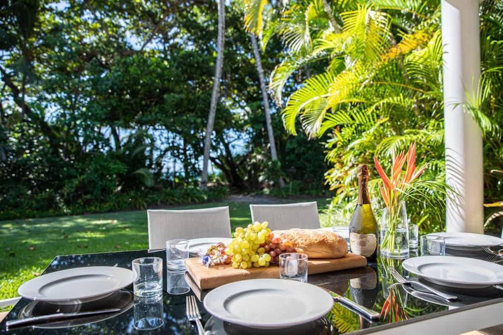 a table with plates of food and a bottle of wine at Port Douglas Mirage Villa 433 - Beachfront in Port Douglas