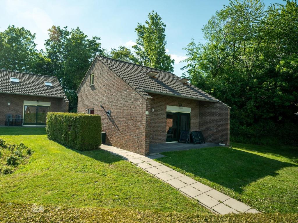 a brick house with a walkway in the yard at Holiday Home in South Limburg in Vijlen