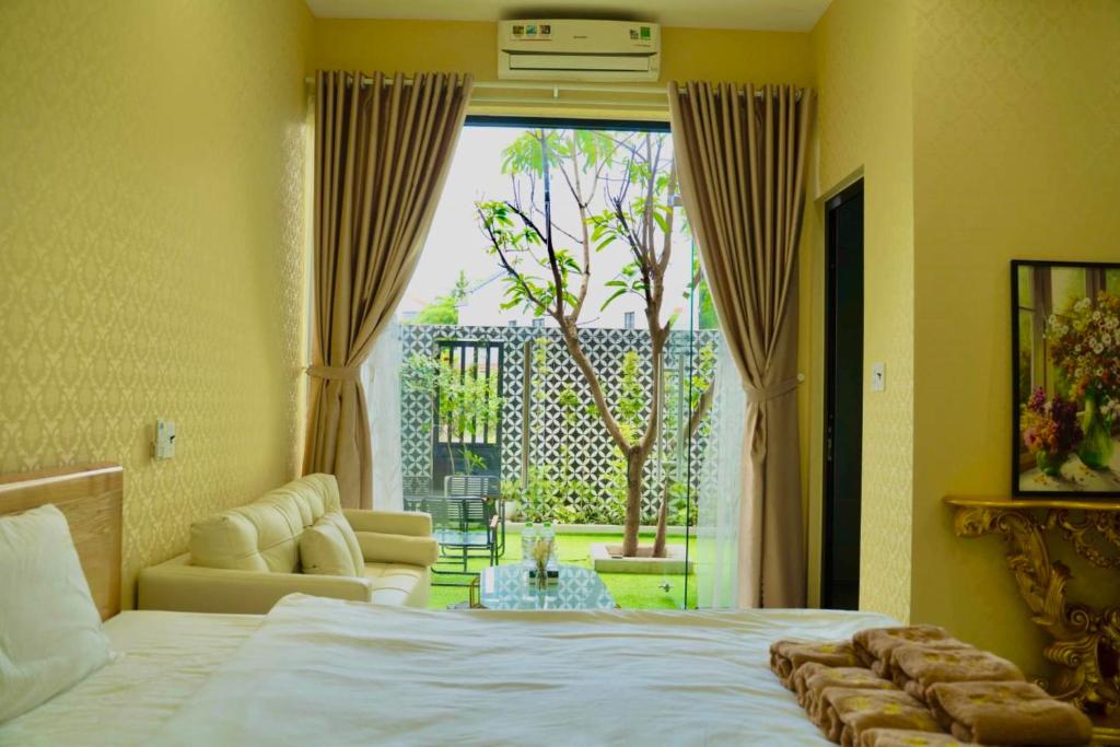 a bedroom with a bed and a view of a patio at Thẩn Thơ Homestay in Hue
