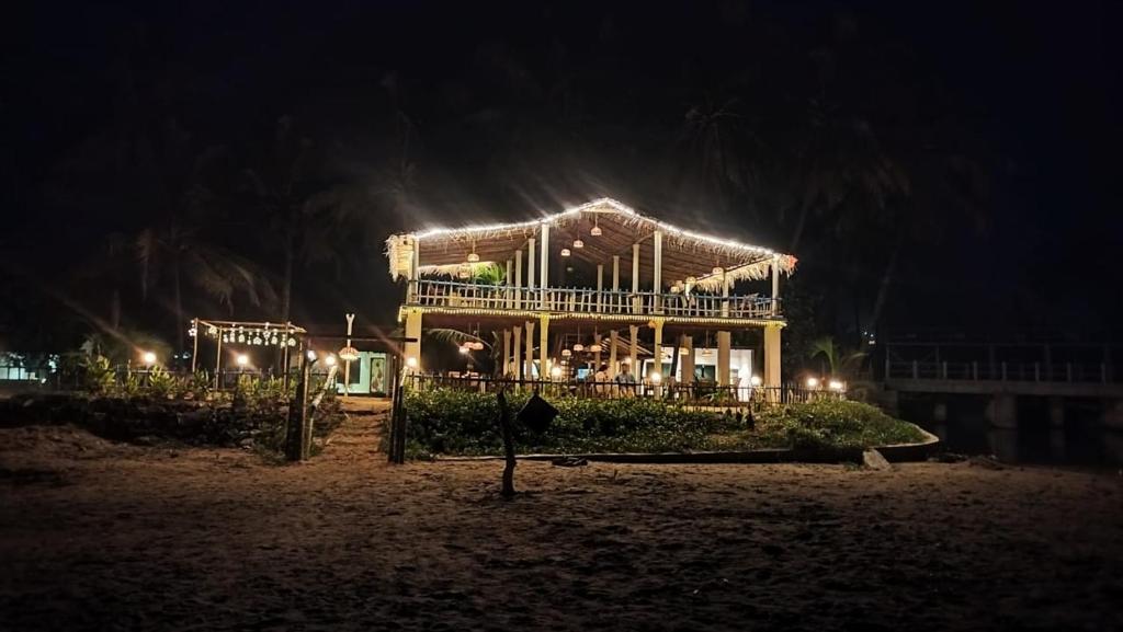 a house with lights on the beach at night at Coconut tree cafe Gokarna in Gokarna