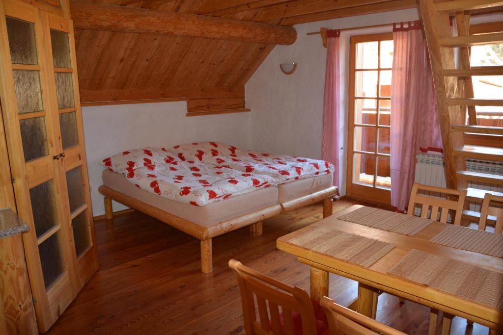 a bedroom with a bed and a table and chairs at Chalupa Ambra in Prachatice