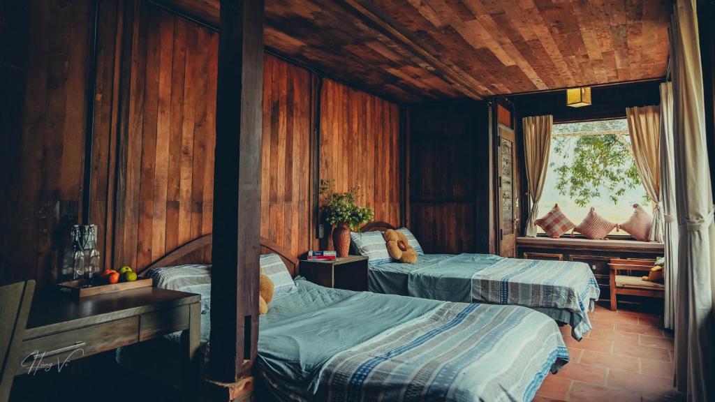 a bedroom with two beds and a window at Đến Nơi Có Gió - Homestay And Coffee in Hữu Lũng