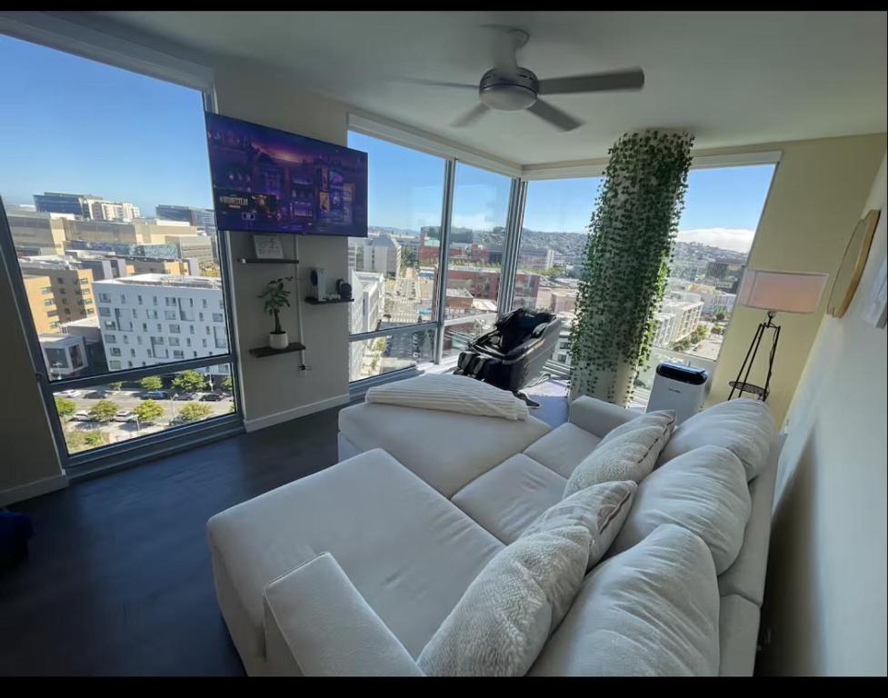 ein Wohnzimmer mit einem weißen Sofa und großen Fenstern in der Unterkunft Skyline & Ocean Views I Faith Filled SF Stay Gym in San Francisco