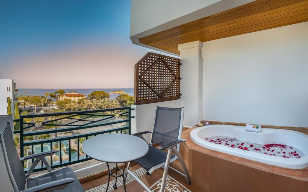 a balcony with a tub and a table and chairs at SH Villa Gadea in Altea