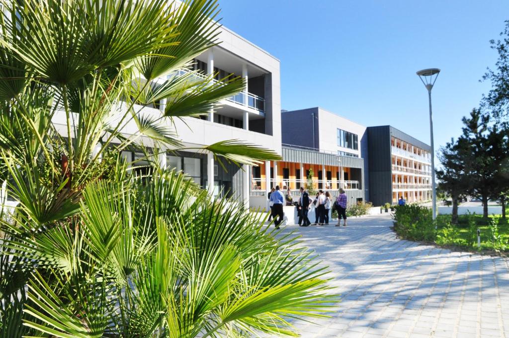 a group of people walking in front of a building at Westotel Life Appart'hotels Pornic - Résidence 4 etoiles in Pornic