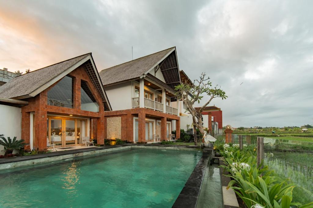 a house with a swimming pool in front of a house at Dewi Sri Villa in Ubud