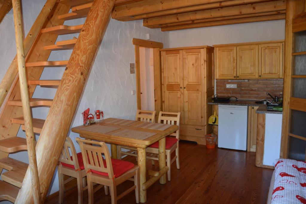 una cucina e una sala da pranzo con tavolo e sedie in legno di Chalupa Ambra a Prachatice