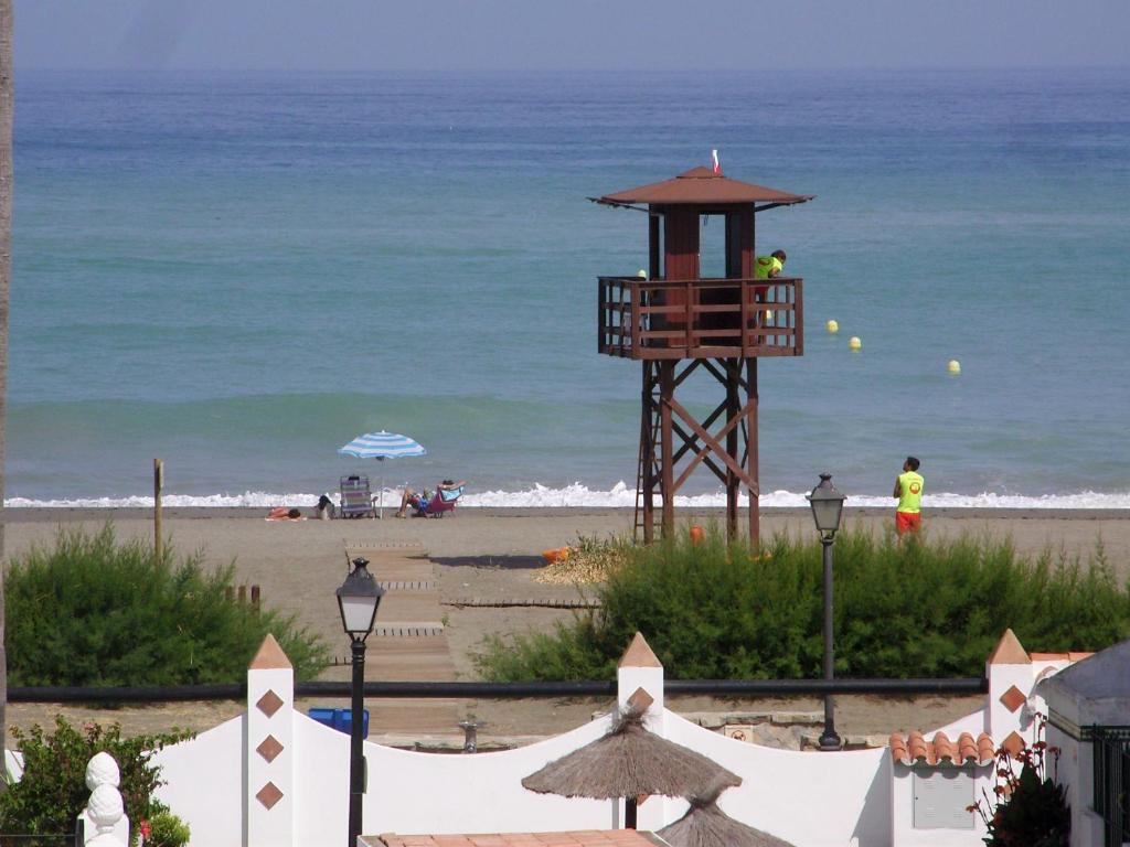 una torre de salvavidas en la playa cerca del océano en Casa de la Playa, en San Luis de Sabinillas